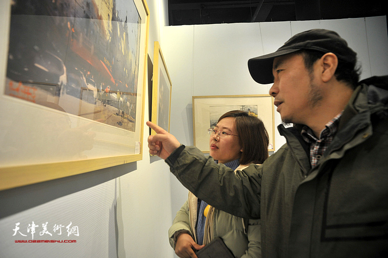 杨俊甫在画展现场为孔滋讲解作品。