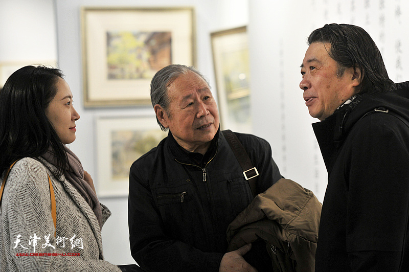 李宗儒、吕建成在画展现场交谈。