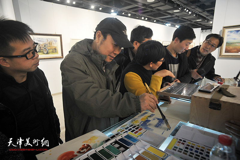 杨俊甫在画展现场试用水彩颜料。