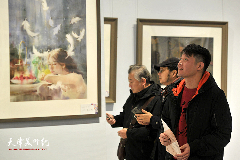 沙志国、贾建东、李垚在画展现场观看作品。