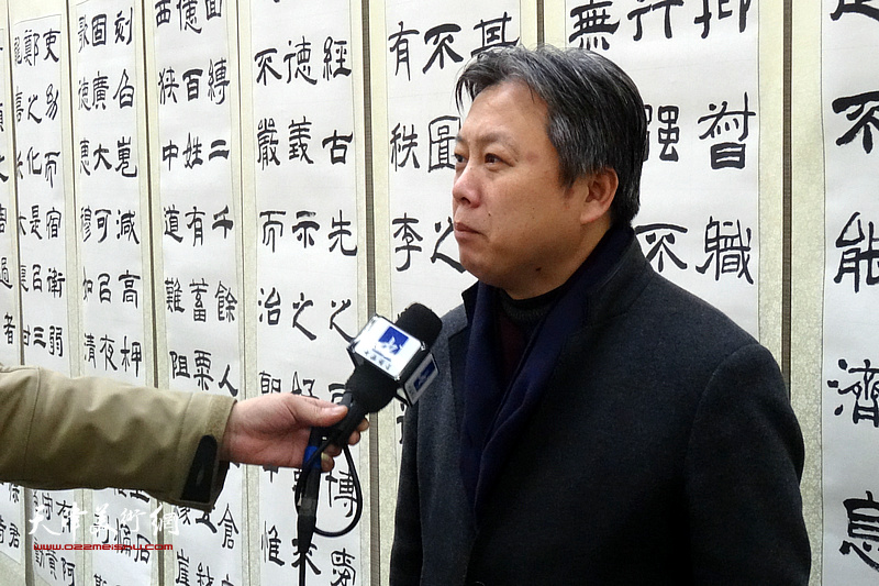 杨健君在展览现场接受媒体采访。