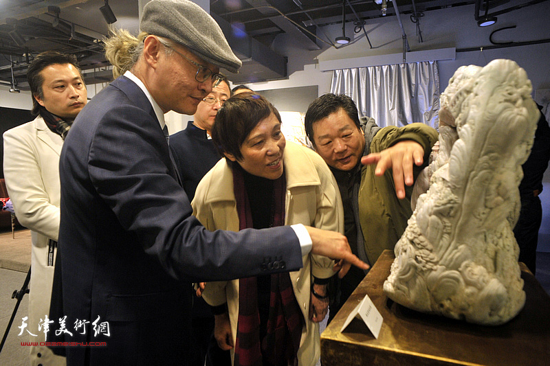 杜雷向韩秀云、孙晓东介绍石雕作品《赶大营风云录》。