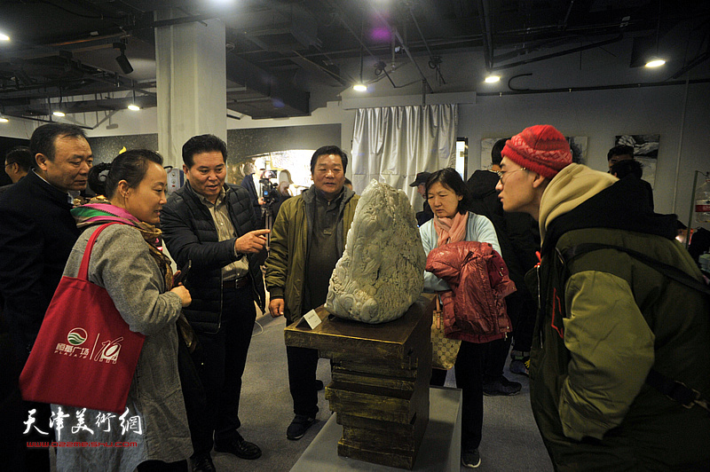 观众在展览现场欣赏石雕作品《赶大营风云录》。