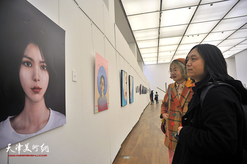郝青松与青年艺术家在展览现场观看作品。