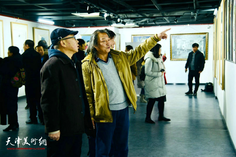 图为刘永吉与来宾在展览现场观赏展品。