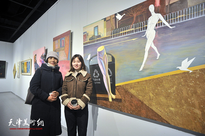 青年艺术家申柳静与母亲在展出的作品《寂寞的街》前。