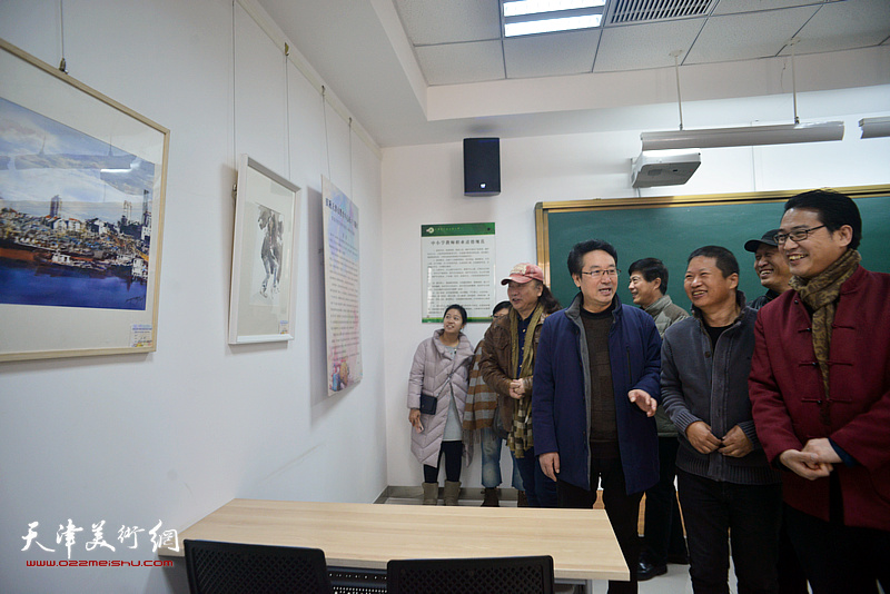 卞永海、王哲成、朱志刚、滑寒冰、魏瑞江在画展现场观看画作。