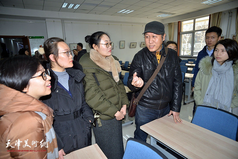 王刚与部分参展教师在画展现场交流。
