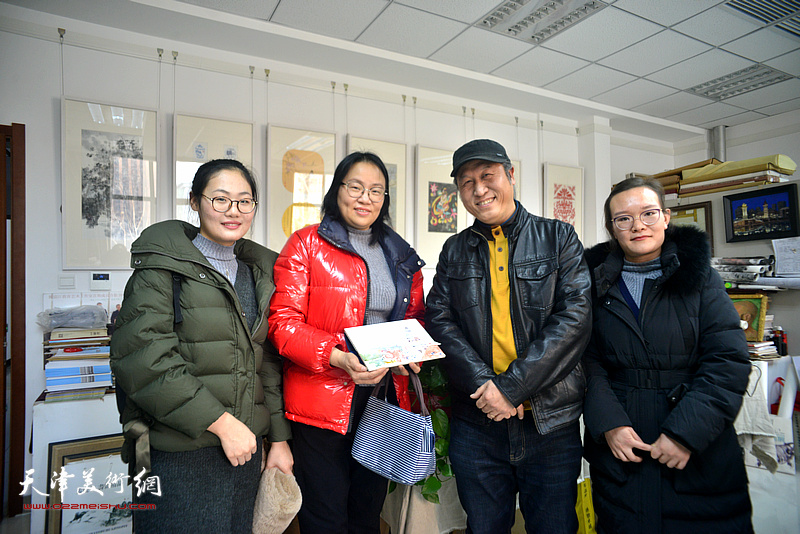 王刚与参展教师张源锦、赵丹擎在画展现场。