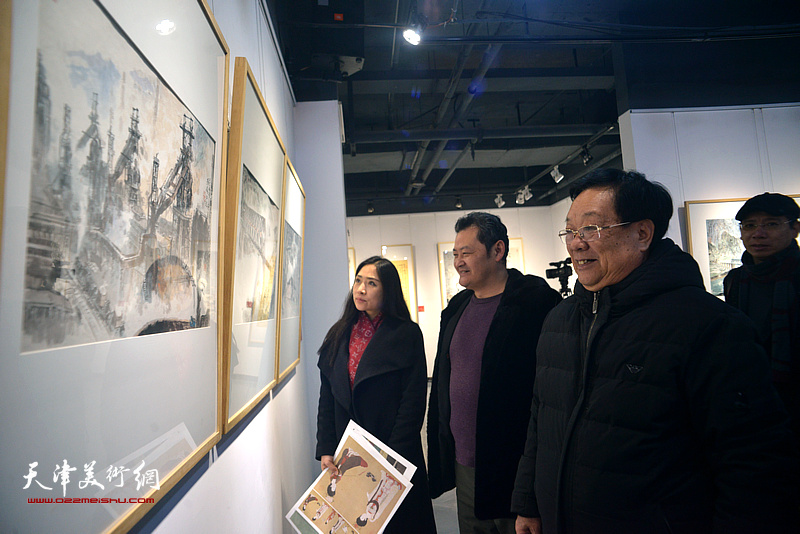 丁玉来、白鹏、王紫萱在画展现场观看画作。