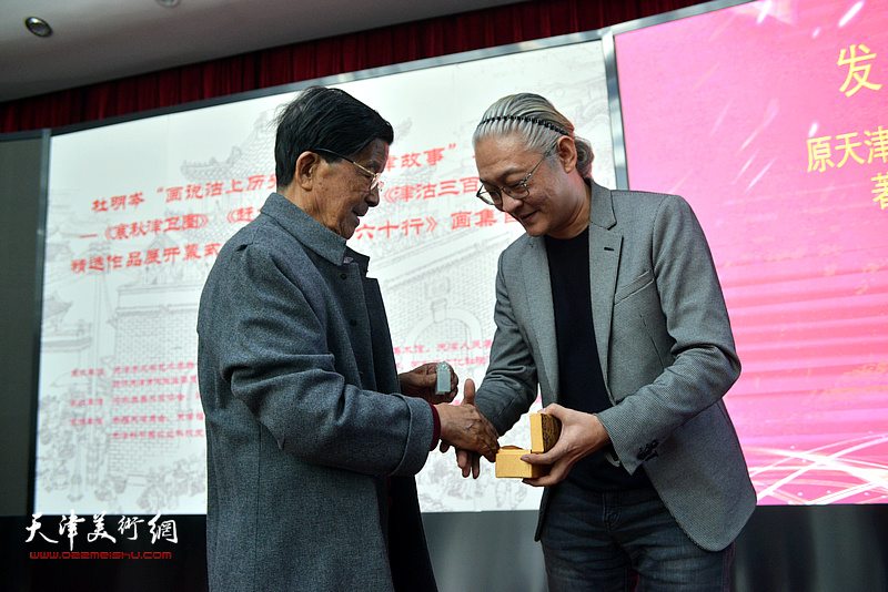 天津宝玉石文化分会会长孙晓东向杜明岑先生赠送玉印。