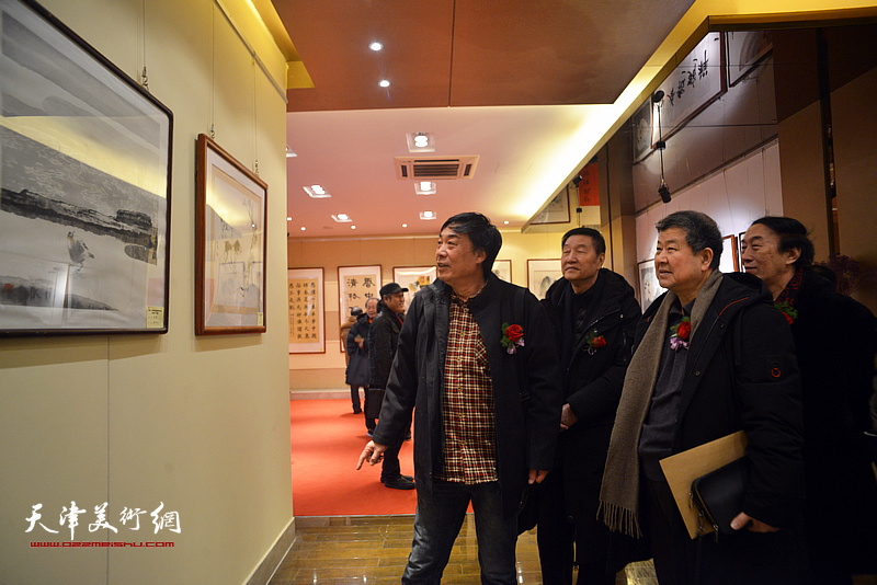 张金方、王学书、李岳林、杜晓光在观看展出的作品。