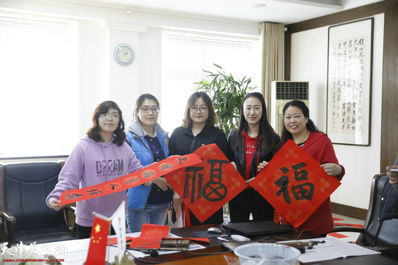 天津建城基业集团的职工们在送书画进万家活动现场。