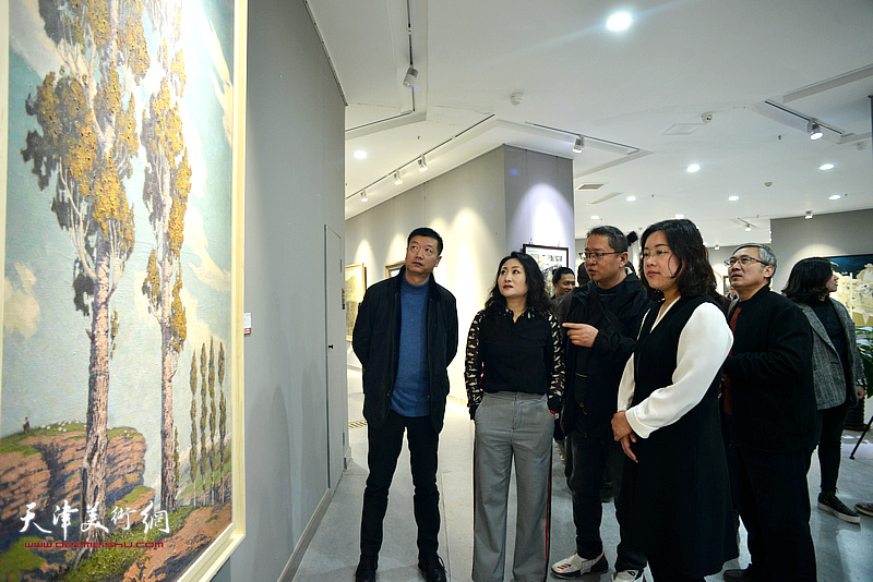 青海画家韵文江向崔俊杰、甘泉、邢晓阳、徐瑾介绍展出的作品。