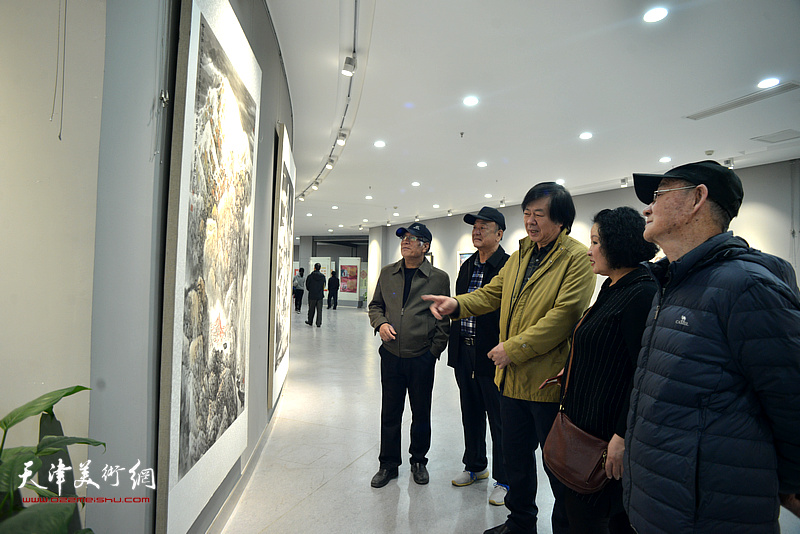 史振岭与陈秀玲等东丽区书画爱好者在观赏展出的作品。