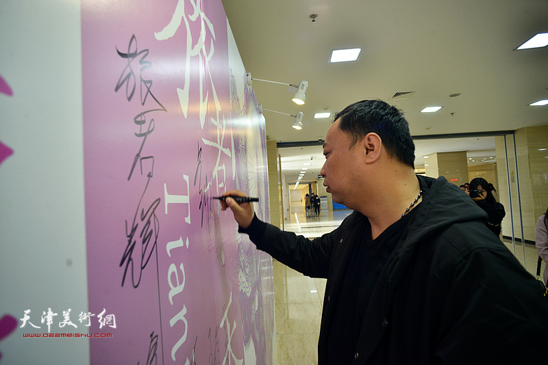 刘悦在签到墙上签名留念。