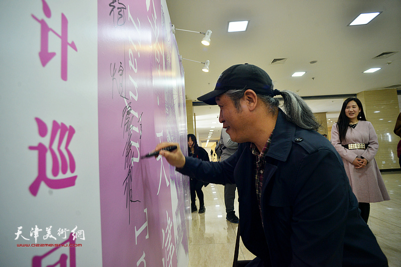 王刚在签到墙上签名留念。
