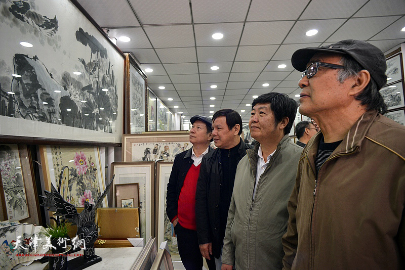 郭书仁、张建华、王惠民、李根友观赏展出的画作。