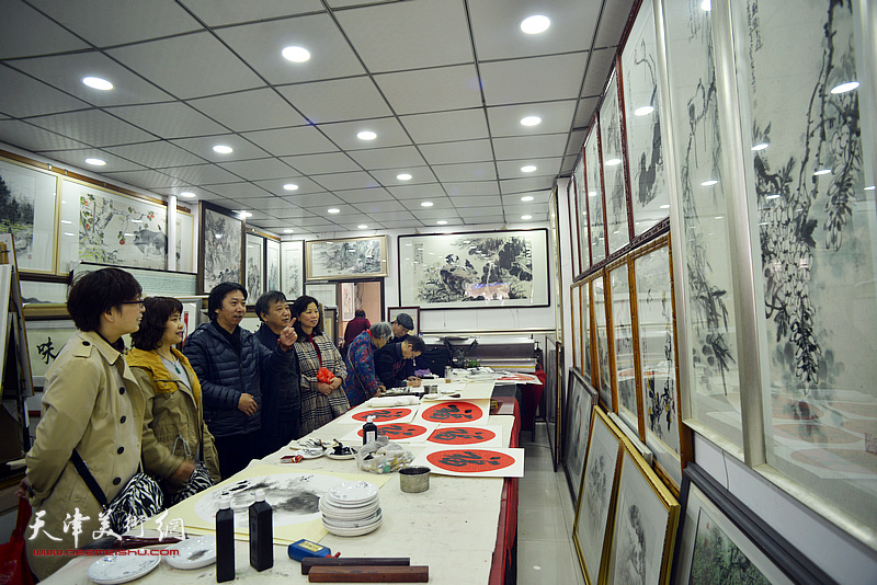 董景波、刘长利观赏展出的画作。