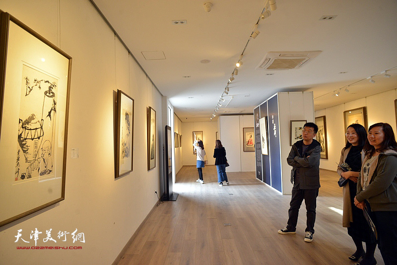 尤佳与来宾在画展现场观赏梁崎先生画作。