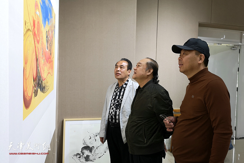 李寅虎在画展现场陪同嘉宾观赏作品。