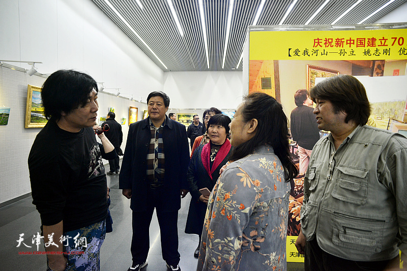 姚志刚与嘉宾在画展现场交流。