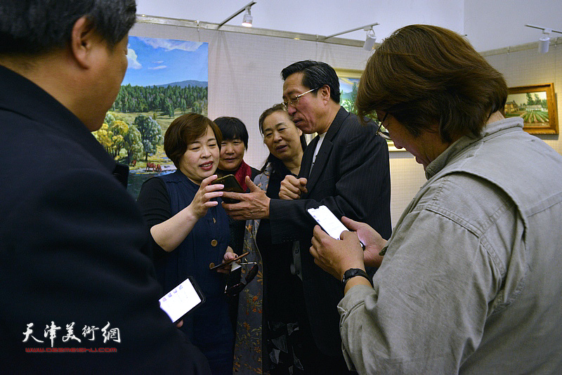 于连水与观众在画展现场交流。