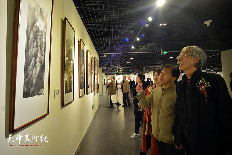 姚景卿、王宏志在画展现场观看作品。