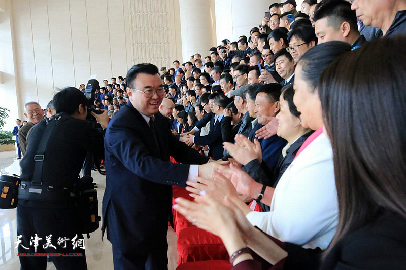 中国硬笔书法协会主席张华庆亲切与各地出席会议的代表见面。