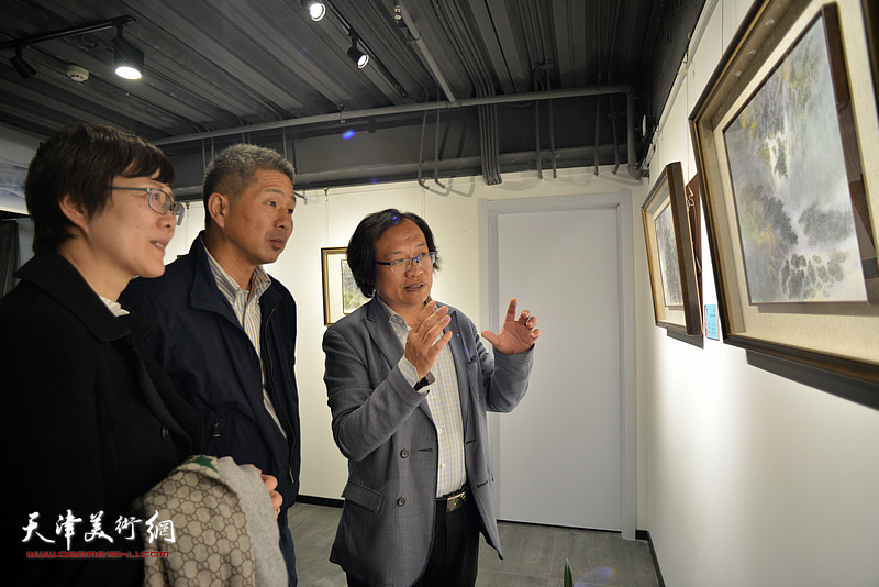 杨惠东等在画展现场观看作品。