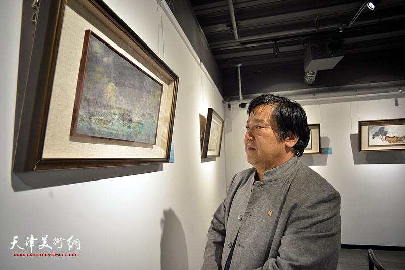 李耀春在画展现场观看作品。