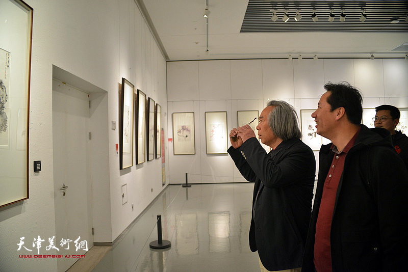 霍春阳先生与李亚在画展现场观看作品。