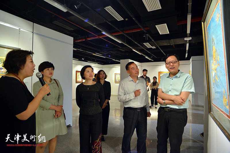 阎妍为宋杨、曲维和、李孝辉、李静等介绍展出的唐卡艺术作品。