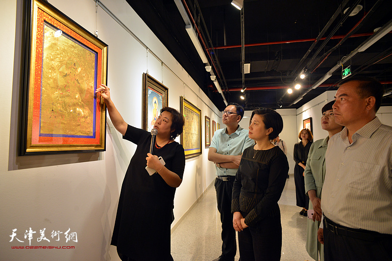 阎妍为宋杨、曲维和、李孝辉、李静等介绍展出的唐卡艺术作品。