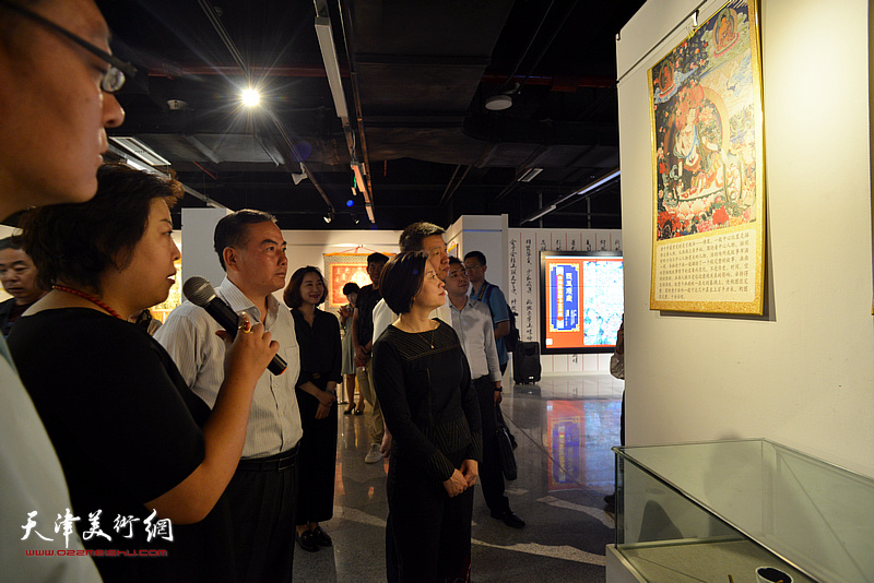 阎妍为宋杨、曲维和、李孝辉等介绍展出的唐卡艺术作品。