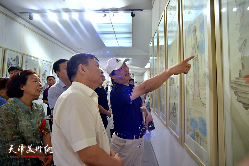 刘志君在画展现场向高唐的嘉宾介绍展出的作品。