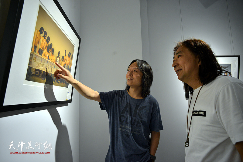杨亦谦、郝青松观赏展出的李维立影像作品。