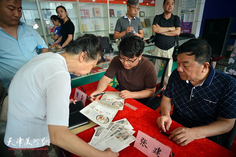 张建、董雷在签售活动现场。