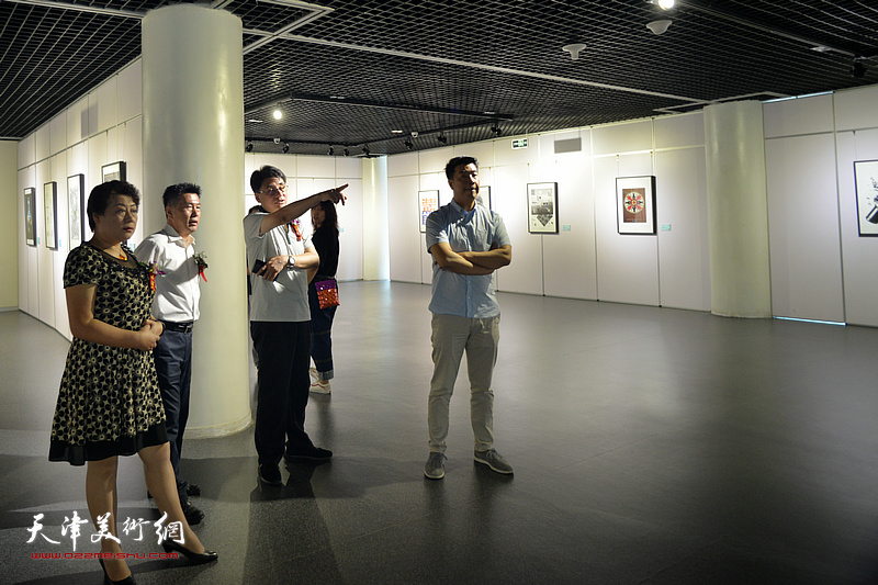 李岩、王萍、郭振山、王中谋观赏展出的设计作品。