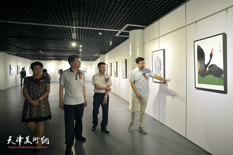 李岩、王萍、郭振山、王中谋观赏展出的设计作品。
