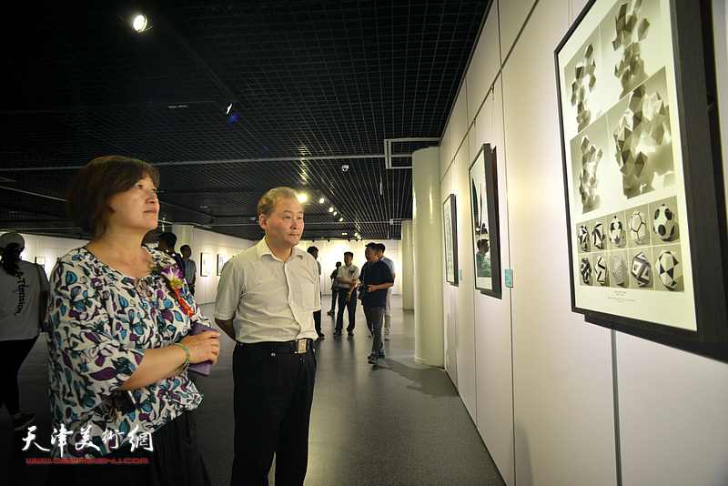 乔银萍与来宾观赏展出的设计作品。