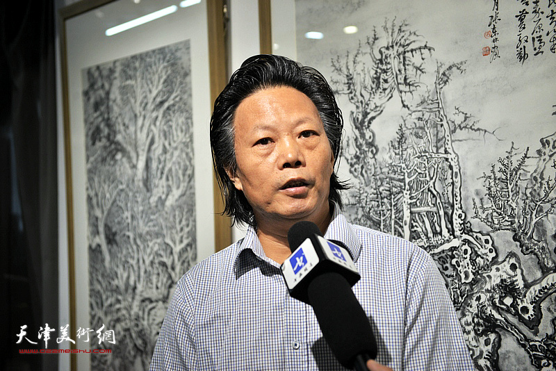 张东林在画展现场接受媒体采访。