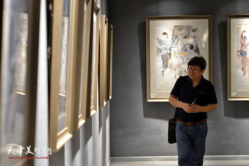 李维立在画展现场观看作品。
