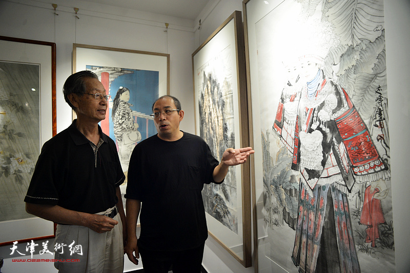 刘建华、姜志峰在画展现场观看作品。