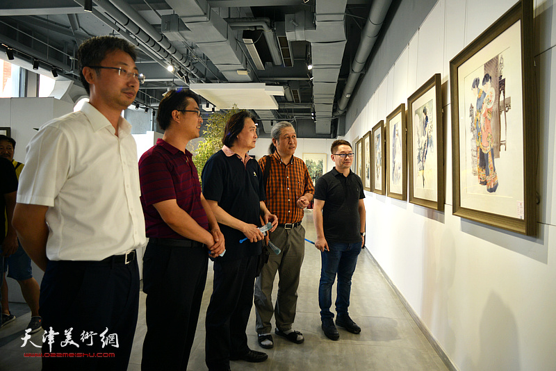 刘国宁、薛义、王刚、滑寒冰、侯立新观赏展出的彩墨作品。