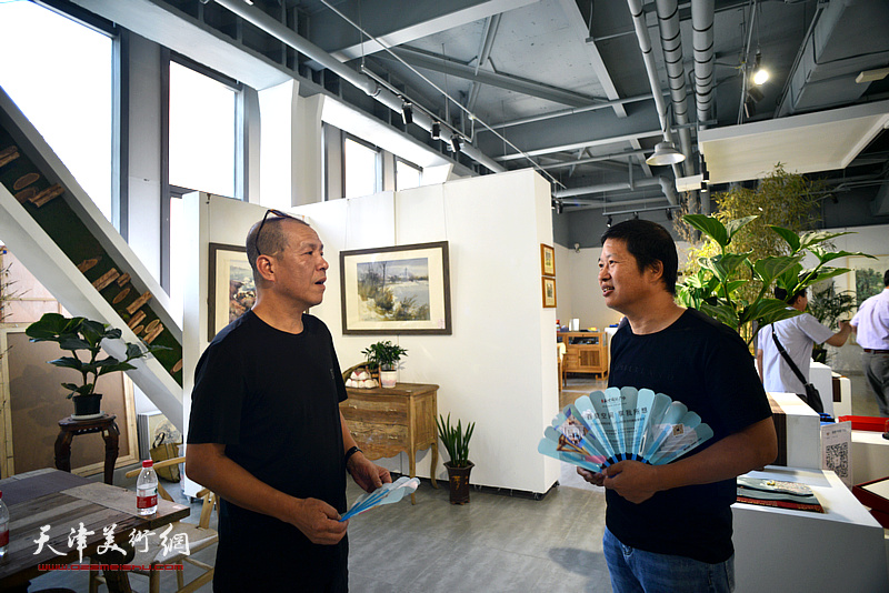 尚金凯、魏瑞江在彩墨作品展现场交流。