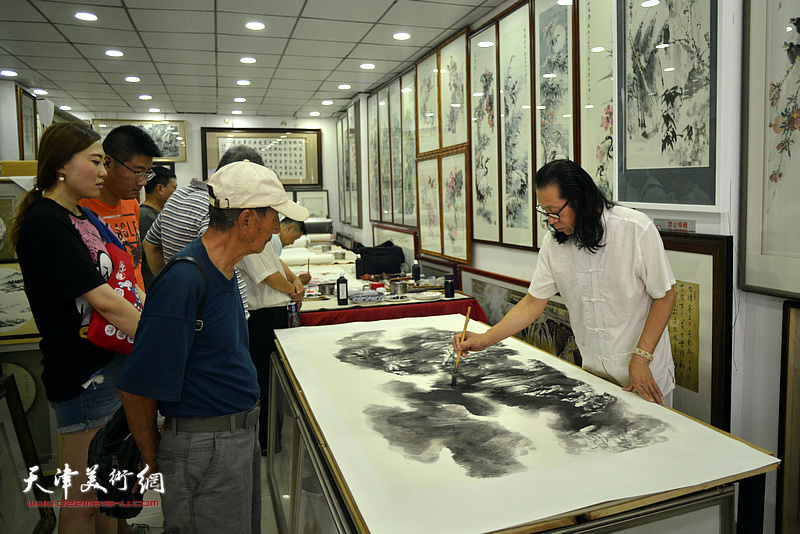 著名山水画家张葆东在鼓楼鹤艺轩创作大幅泼彩山水画作《溪山无尽》。
