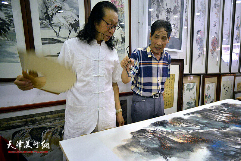 卢炳剑欣赏张葆东的泼彩巨幅作品《溪山无尽》。