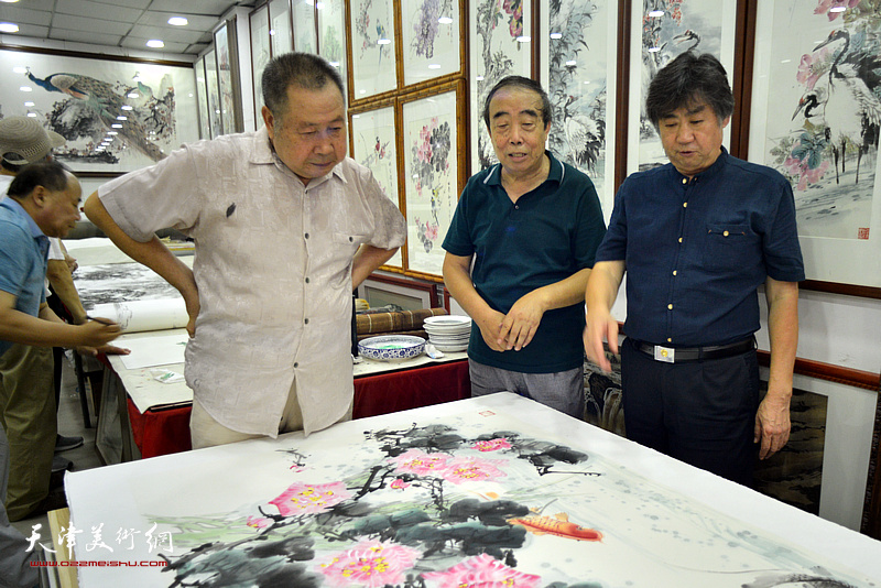 左起：武子明、贾春明、李兆河在鹤艺轩合作巨幅花鸟画《富贵有余》图。