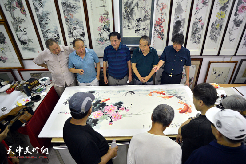 贾春明、武子明、李兆河在鹤艺轩合作巨幅花鸟画《富贵有余》图。
